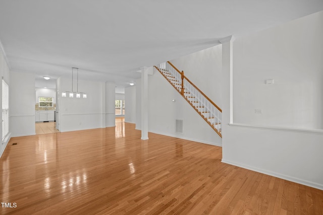 324 Farrow Glen Loop, Cary, NC 27519 - unfurnished living room with light wood finished floors, stairway, and baseboards