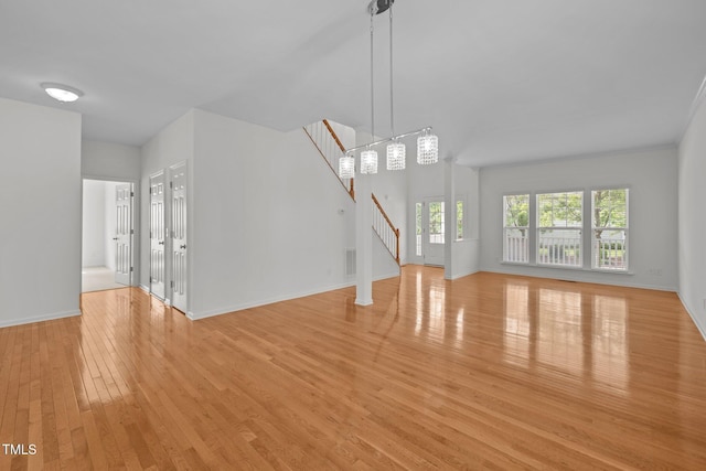 324 Farrow Glen Loop, Cary, NC 27519 - unfurnished living room with light wood-style floors, stairs, and baseboards