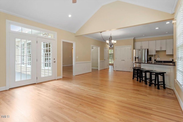 1211 E Pointe Dr, Durham, NC 27712 - unfurnished living room with a chandelier, light wood-style floors, crown molding, high vaulted ceiling, and a sink