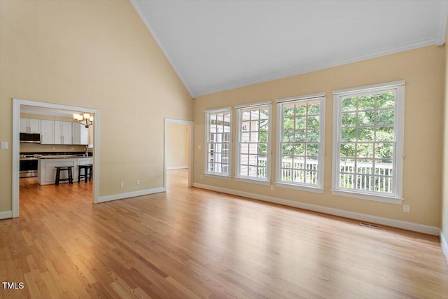 1211 E Pointe Dr, Durham, NC 27712 - empty room featuring a chandelier, ornamental molding, baseboards, healthy amount of natural light, and light wood finished floors