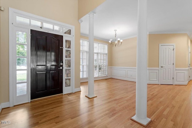 1211 E Pointe Dr, Durham, NC 27712 - entrance foyer with decorative columns, ornamental molding, a chandelier, wood finished floors, and a wainscoted wall