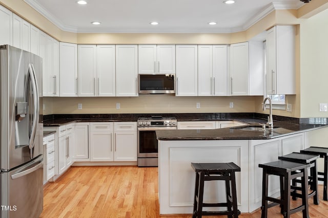 1211 E Pointe Dr, Durham, NC 27712 - kitchen with stainless steel appliances, a peninsula, ornamental molding, a sink, and white cabinets
