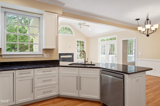 1211 E Pointe Dr, Durham, NC 27712 - kitchen featuring stainless steel dishwasher, a sink, vaulted ceiling, white cabinetry, and dark stone countertops