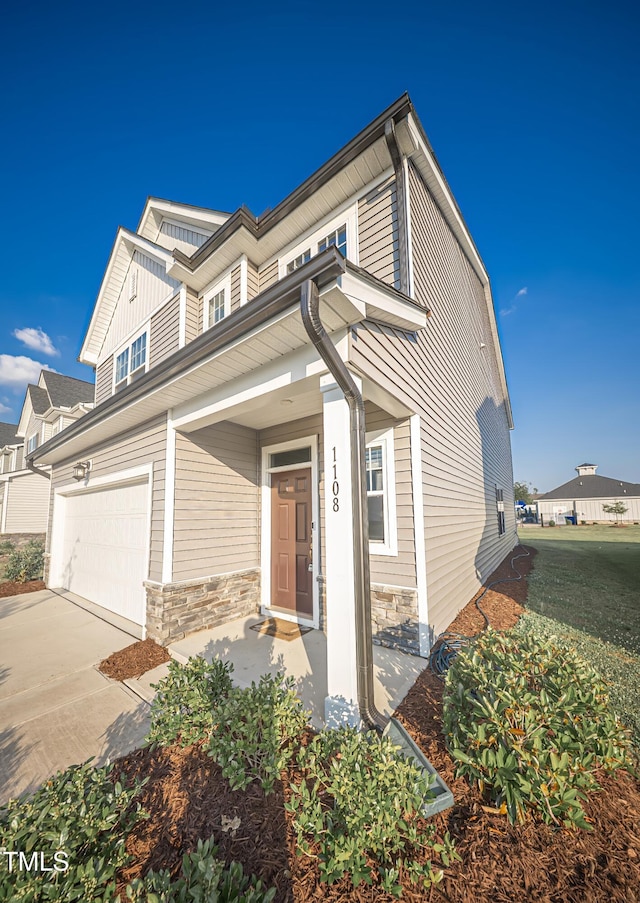 1108 Matterhorn Dr, Fuquay Varina, NC 27526 - view of front of home with a garage, stone siding, and concrete driveway