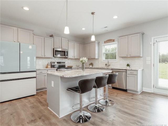298 Turkey Trot Ln, Raeford, NC 28376 - kitchen featuring appliances with stainless steel finishes, tasteful backsplash, light wood-type flooring, a center island, and recessed lighting