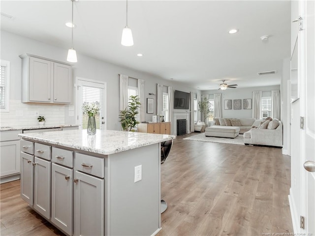 298 Turkey Trot Ln, Raeford, NC 28376 - kitchen with gray cabinetry, plenty of natural light, a fireplace, a center island, and recessed lighting
