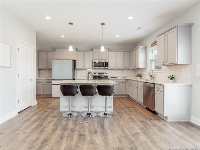 298 Turkey Trot Ln, Raeford, NC 28376 - kitchen with stainless steel appliances, decorative backsplash, gray cabinetry, a center island, and recessed lighting