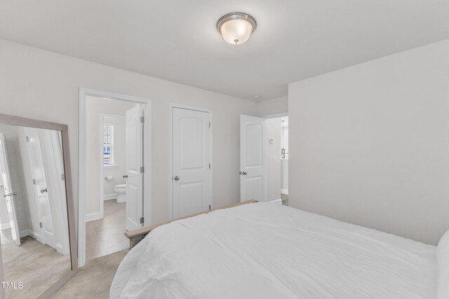 520 Oak Holly Ln, Zebulon, NC 27597 - bedroom featuring connected bathroom and baseboards