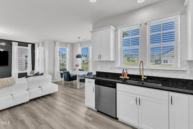 520 Oak Holly Ln, Zebulon, NC 27597 - kitchen featuring stainless steel dishwasher, a sink, white cabinetry, tasteful backsplash, and light wood finished floors