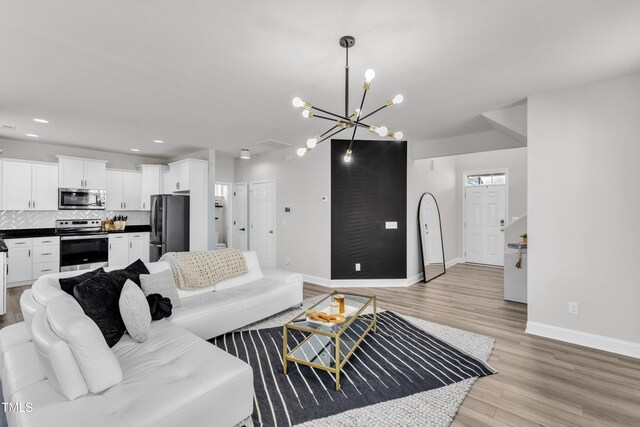 520 Oak Holly Ln, Zebulon, NC 27597 - living room featuring a chandelier, light wood-style flooring, baseboards, and recessed lighting