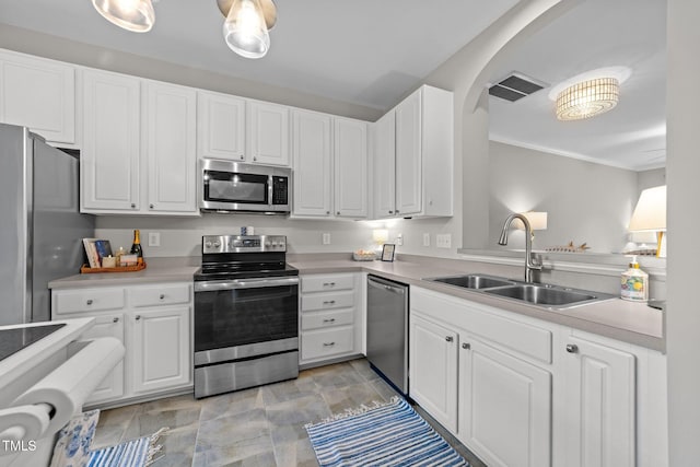 5717 Corbon Crest Ln, Raleigh, NC 27612 - kitchen featuring stainless steel appliances, white cabinets, light countertops, arched walkways, and crown molding