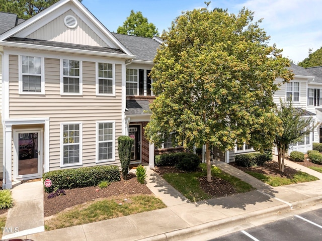 5717 Corbon Crest Ln, Raleigh, NC 27612 - view of property featuring board and batten siding, uncovered parking, and roof with shingles