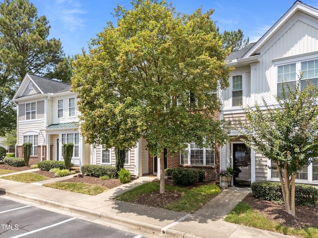 5717 Corbon Crest Ln, Raleigh, NC 27612 - view of property with brick siding, board and batten siding, uncovered parking, and a shingled roof