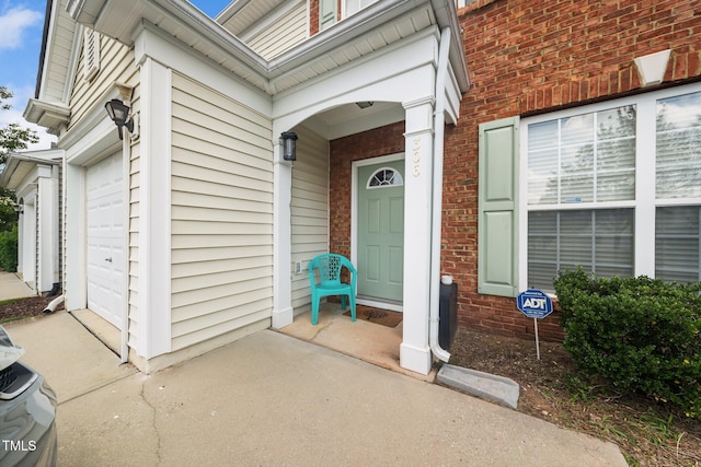 306 Berlin Way, Morrisville, NC 27560 - property entrance featuring brick siding, concrete driveway, and a garage