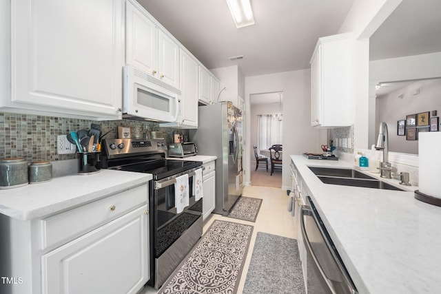 306 Berlin Way, Morrisville, NC 27560 - kitchen with stainless steel appliances, a sink, decorative backsplash, and white cabinetry