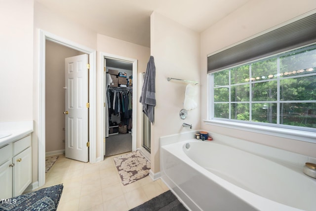 306 Berlin Way, Morrisville, NC 27560 - bathroom featuring a garden tub, a walk in closet, tile patterned floors, vanity, and a stall shower