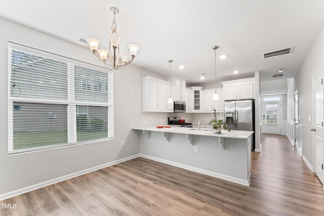 515 Historic Dr, Hillsborough, NC 27278 - kitchen with appliances with stainless steel finishes, a peninsula, light countertops, glass insert cabinets, and a chandelier