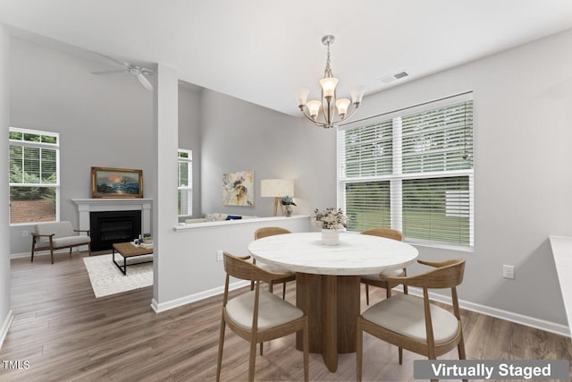 515 Historic Dr, Hillsborough, NC 27278 - dining area with a chandelier, wood finished floors, a fireplace, and a ceiling fan