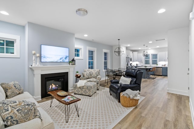 1534 Millrock Trl, Wendell, NC 27591 - living area with light wood-style floors, a glass covered fireplace, baseboards, recessed lighting, and a chandelier