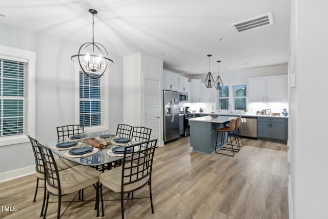 1534 Millrock Trl, Wendell, NC 27591 - dining space with a chandelier, light wood-type flooring, and baseboards