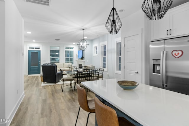 1534 Millrock Trl, Wendell, NC 27591 - kitchen featuring stainless steel refrigerator with ice dispenser, a chandelier, light wood finished floors, white cabinets, and recessed lighting