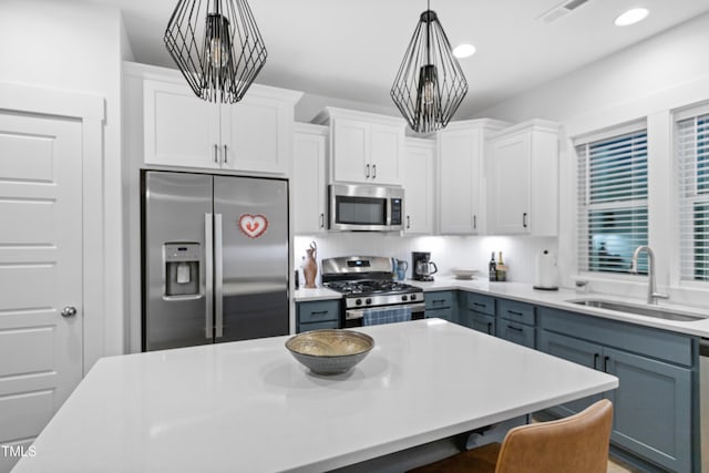 1534 Millrock Trl, Wendell, NC 27591 - kitchen featuring stainless steel appliances, a sink, white cabinets, hanging light fixtures, and a breakfast bar