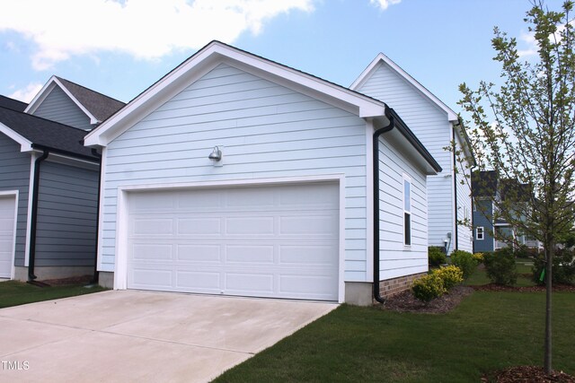 1534 Millrock Trl, Wendell, NC 27591 - view of side of home with driveway, an attached garage, and a yard