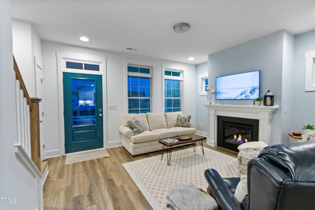 1534 Millrock Trl, Wendell, NC 27591 - living room with wood finished floors, stairway, a glass covered fireplace, recessed lighting, and baseboards