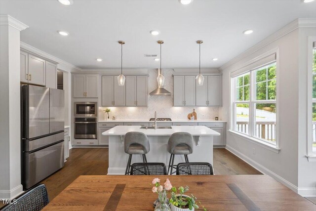 74 Permit Ct, Chapel Hill, NC 27517 - kitchen with appliances with stainless steel finishes, light countertops, dark wood-style floors, tasteful backsplash, and a kitchen island with sink
