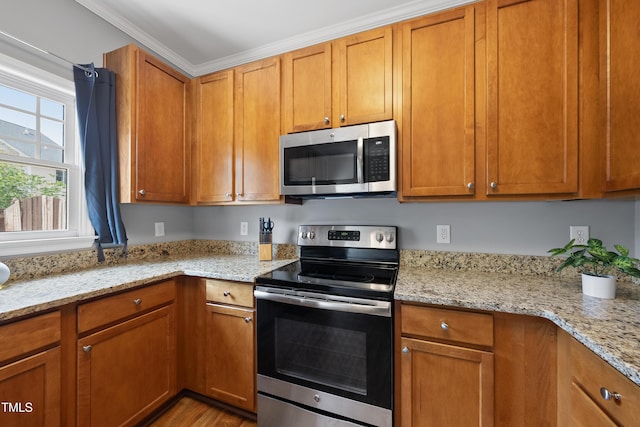1154 Bungalow Park Dr, Apex, NC 27502 - kitchen with stainless steel appliances, light stone counters, wood finished floors, and brown cabinets