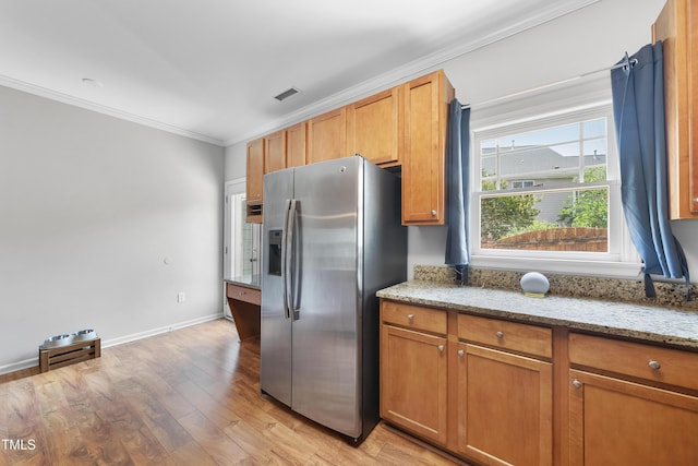 1154 Bungalow Park Dr, Apex, NC 27502 - kitchen with stainless steel fridge with ice dispenser, ornamental molding, light wood-type flooring, light stone counters, and baseboards