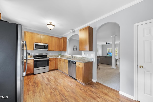 1154 Bungalow Park Dr, Apex, NC 27502 - kitchen featuring stainless steel appliances, arched walkways, a ceiling fan, a sink, and light wood-style floors