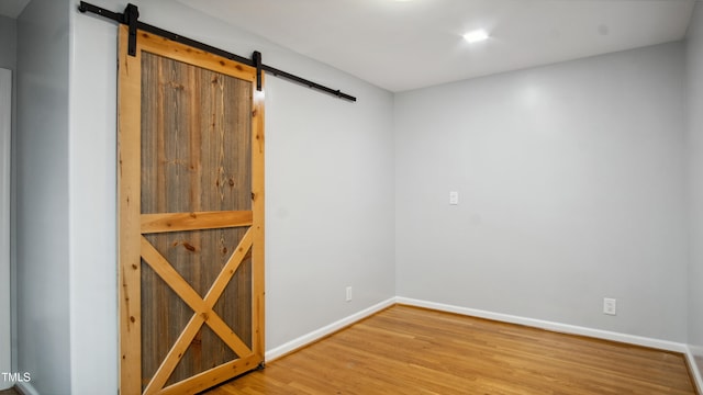 5820 Wake Forest Highway, Durham, NC 27703 - empty room with a barn door, wood finished floors, and baseboards