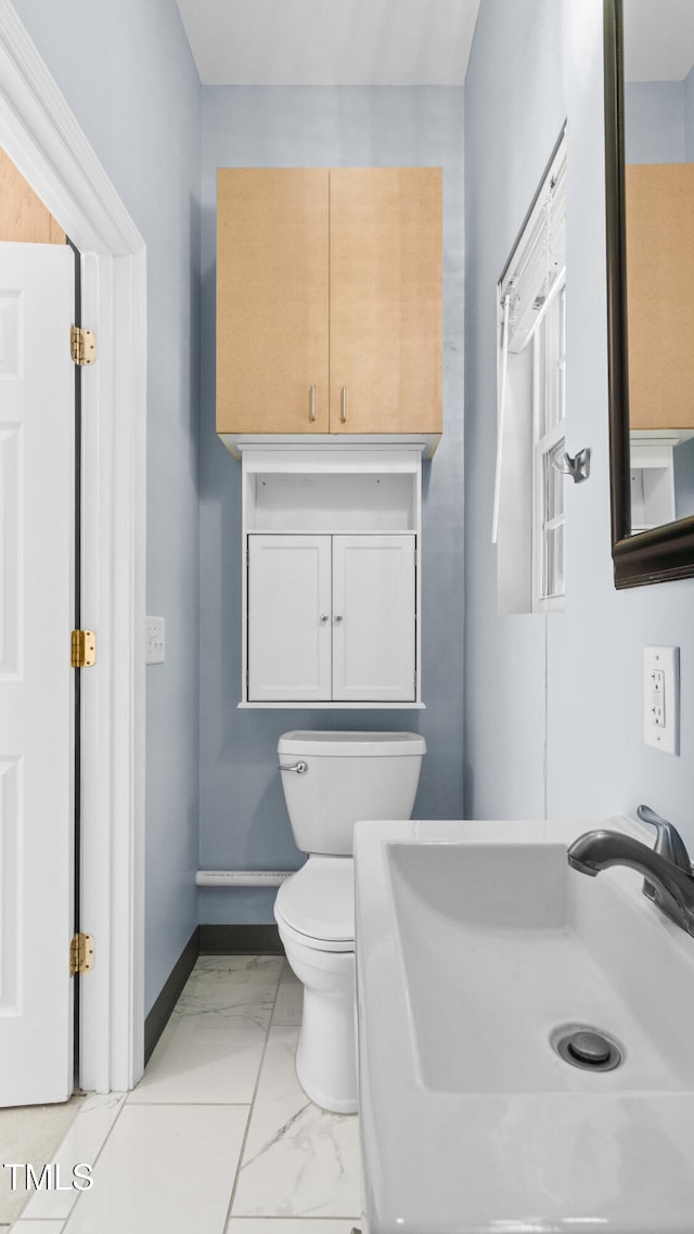 5820 Wake Forest Highway, Durham, NC 27703 - bathroom with a sink, toilet, marble finish flooring, and baseboards