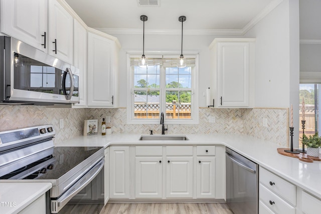 2761 Andover Glen Rd, Raleigh, NC 27604 - kitchen with appliances with stainless steel finishes, a sink, white cabinetry, and ornamental molding