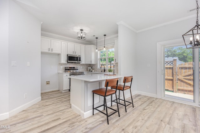 2761 Andover Glen Rd, Raleigh, NC 27604 - kitchen featuring a chandelier, stainless steel appliances, a sink, light wood finished floors, and light countertops