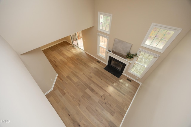 105 Old Dock Trl, Cary, NC 27519 - unfurnished living room with a towering ceiling, light wood finished floors, and a fireplace with flush hearth