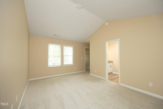 105 Old Dock Trl, Cary, NC 27519 - unfurnished bedroom with light carpet, a walk in closet, lofted ceiling, and baseboards