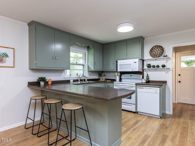 114 Brenrose Cir, Durham, NC 27705 - kitchen featuring white appliances, dark countertops, a peninsula, a sink, and light wood finished floors