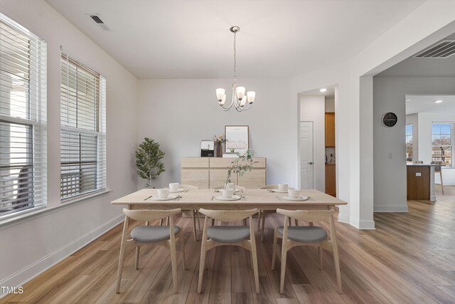 46 Two Belles Ct, Angier, NC 27501 - dining area with baseboards, light wood-type flooring, and a chandelier