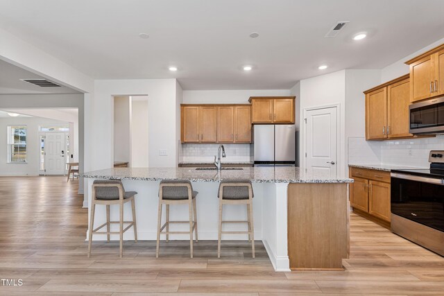 46 Two Belles Ct, Angier, NC 27501 - kitchen featuring stainless steel appliances, a sink, tasteful backsplash, light stone counters, and recessed lighting