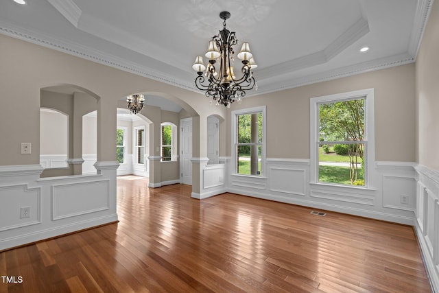 7409 Chesley Ln, Durham, NC 27713 - unfurnished dining area featuring a chandelier, ornamental molding, a wainscoted wall, hardwood / wood-style floors, and arched walkways