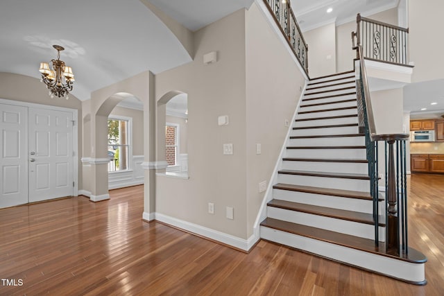 7409 Chesley Ln, Durham, NC 27713 - foyer featuring arched walkways, wood finished floors, baseboards, a chandelier, and stairs