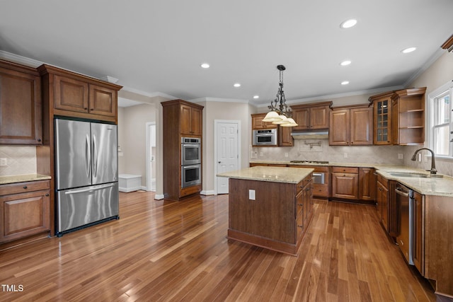 7409 Chesley Ln, Durham, NC 27713 - kitchen featuring stainless steel appliances, a sink, backsplash, a kitchen island, and wood finished floors