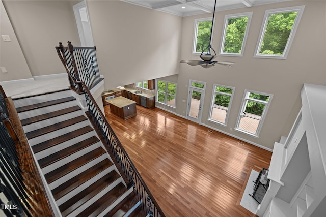 7409 Chesley Ln, Durham, NC 27713 - stairway with crown molding, healthy amount of natural light, wood finished floors, a ceiling fan, and baseboards