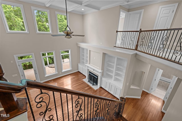7409 Chesley Ln, Durham, NC 27713 - stairs featuring ceiling fan, wood finished floors, coffered ceiling, beam ceiling, and crown molding