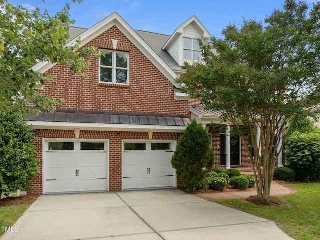 7409 Chesley Ln, Durham, NC 27713 - view of front of home with brick siding, driveway, an attached garage, a standing seam roof, and metal roof
