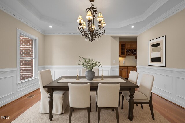 7409 Chesley Ln, Durham, NC 27713 - dining space featuring a tray ceiling, recessed lighting, a chandelier, wood finished floors, and ornamental molding