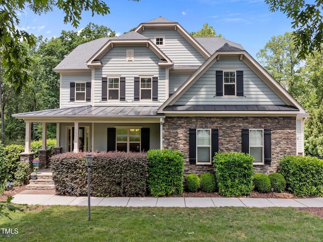12216 Kyle Abbey Ln, Raleigh, NC 27613 - view of front of home with a standing seam roof, stone siding, covered porch, and metal roof