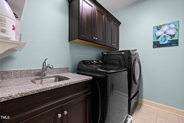 12216 Kyle Abbey Ln, Raleigh, NC 27613 - laundry room featuring washer and dryer, cabinet space, light tile patterned floors, and baseboards